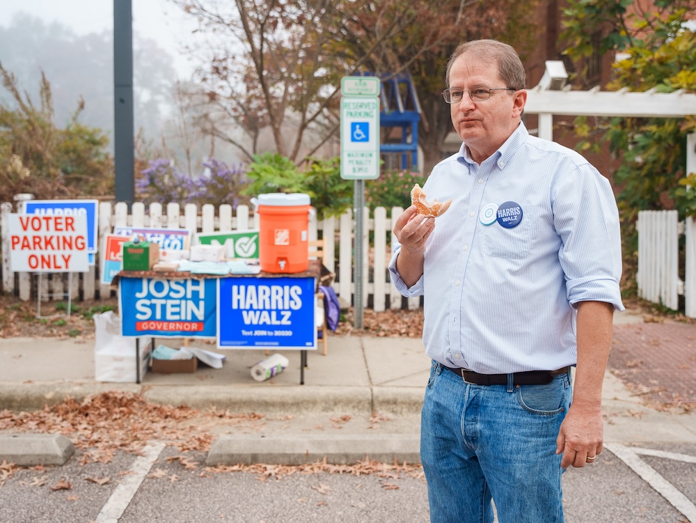 Tom Miller, a Democratic precinct chair, eats a donut