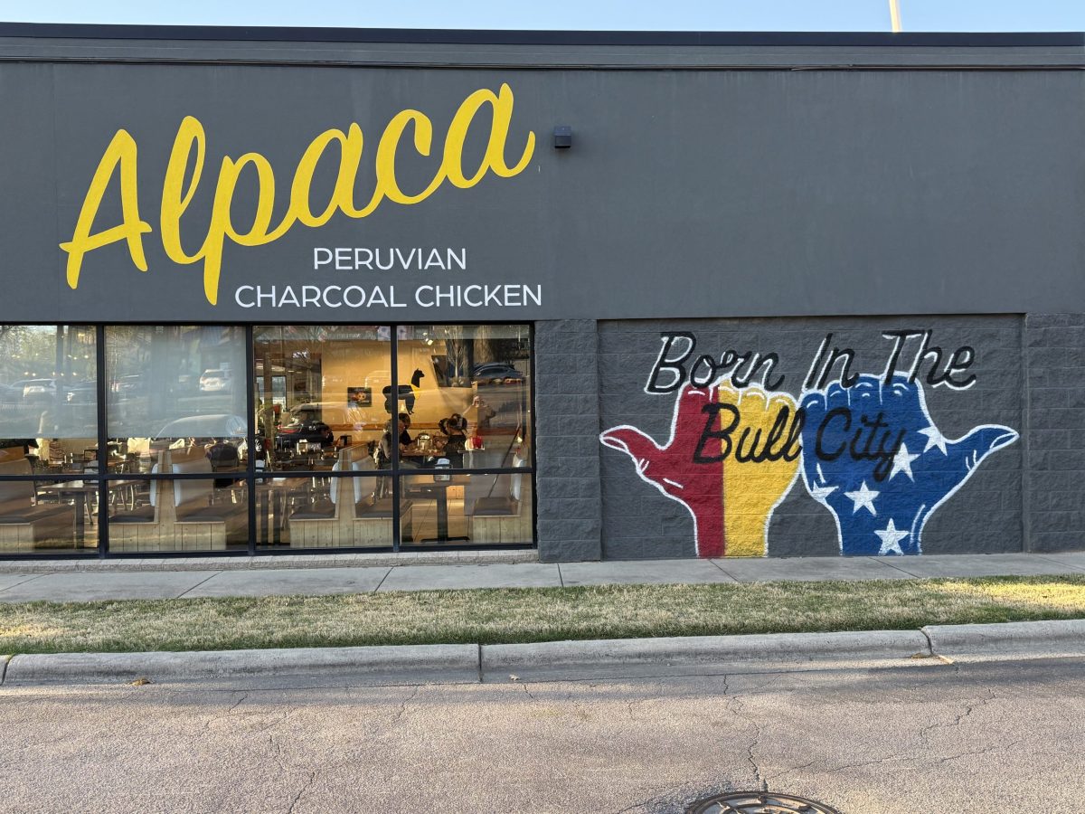 A mural at Alpaca uses Bull City hands to celebrate the restaurant's birthplace.