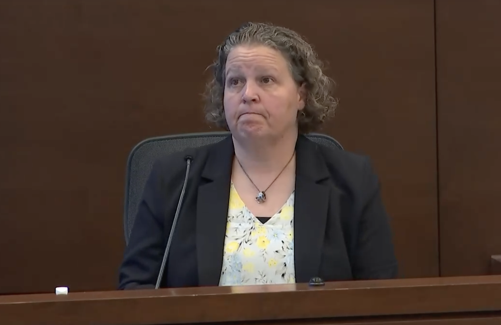 A woman sits in the witness box in court