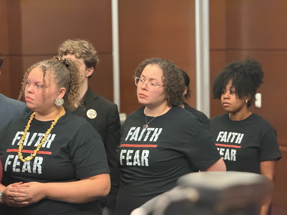 three women stand in black shirts reading faith over fear
